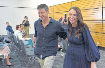  ?? REUTERS ?? New Zealand Prime Minister Jacinda Ardern leaves with longtime partner Clarke Gayford following the announceme­nt of her resignatio­n at the War Memorial Hall, in Napier, New Zealand yesterday.