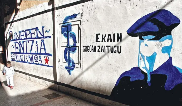  ?? Foto: Juan Herrero, EFE ?? Ein Graffiti im baskischen Hernani mit einem vermummten ETA-Mitglied und dem Emblem aus Axt und Schlange im März 2006.