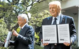  ?? JIM WATSON/GETTY-AFP ?? President Trump and Mexican leader Andres Manuel Lopez Obrador hold up a joint declaratio­n during a news conference Wednesday in the Rose Garden at the White House.