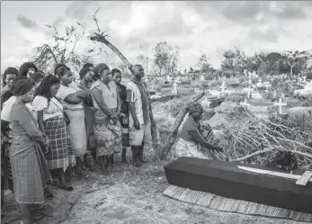  ?? YASUYOSHI CHIBA / AGENCE FRANCE-PRESSE ?? Rebecca Albino (right), a mother of three children, mourns beside the coffin of her husband, Tomas Joaquim Chimukme, during his funeral following a strong cyclone that hit Beira, Mozambique, on Wednesday.