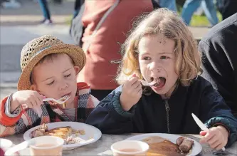  ?? PHOTOS BY PETER LEE WATERLOO REGION RECORD ?? Clyde Winkler, 4, left, and brother Bruce, 6, of Wellesley, eat pancakes at the festival.