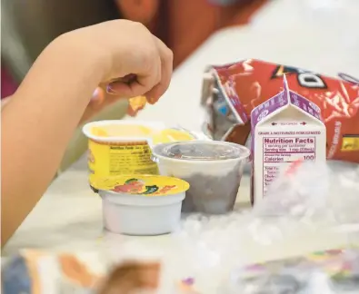  ?? KYLE TELECHAN/POST-TRIBUNE ?? A child eats a nacho cheese meal in 2018 during the free lunch program at the Hobart YMCA.