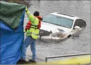  ?? PETE BANNAN — DIGITAL FIRST MEDIA ?? Crews hold tarps to shield the public from viewing a car as it is winched out of the Schuylkill River just off the South Penn Street boat ramp in North Coventry Tuesday afternoon.