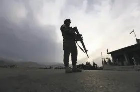  ?? Rahmat Gul / Associated Press ?? An Afghan Army soldier patrols a checkpoint on a highway Saturday east of Kabul. Militants accuse Washington and Kabul of violating a peace deal.