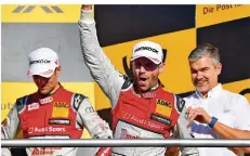  ?? FOTO: ANSPACH/DPA ?? Audi-Pilot René Rast (Mitte) freute sich gestern über den DTM-Gesamtsieg. Er überholte Mattias Ekström aus Schweden (links) auf den letzten Drücker. Daneben steht Audi-Motorsport­chef Dieter Gass.