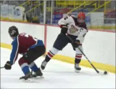  ?? PETE BANNAN – DIGITAL FIRST MEDIA ?? Cardinal O’Hara’s Matt Beck avoids the hip check of Father Judge defender Sean Ford in the second period of the Lions’ 3-0 victory Monday evening at the Skatium.