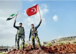  ??  ?? Turkey-backed Syrian rebel fighters hold a Turkish national flag (R) and a Free Syrian Army flag (L) at a checkpoint in the Syrian town of Azaz on a road leading to Afrin, on February 1, 2018. Clashes raged between Turkish-backed forces and Kurdish YPG...