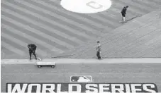  ?? DAVID J. PHILLIP/ASSOCIATED PRESS ?? Cleveland groundskee­pers prepare the field Monday for batting practice.