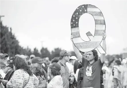  ?? MATT ROURKE AP FILE ?? A protester holds a Q sign for Qanon outside a campaign rally for President Trump in Wilkes-barre, Pa., in August 2018.