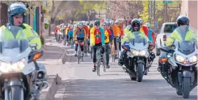  ?? EDDIE MOORE/JOURNAL ?? Police escort 180 bicycle riders on their way to the Roundhouse on April 7, 2016, as a memorial for Clare Rhoades, 72, who was killed last year in Tucson when a man driving a work truck crashed into a group of bicyclists.