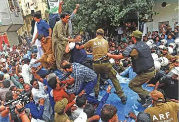  ?? AFP ?? PML-N party supporters stand on an armoured vehicle carrying opposition leader Shahbaz Sharif on his arrival at the corruption court in Lahore yesterday.