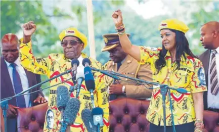  ?? Associated Press file ?? President Robert Mugabe and wife Grace chant a party slogan early this month during a rally in Harare, the capital of Zimbabwe. The military has taken the two into custody.