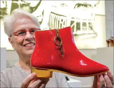  ?? Arkansas Democrat-Gazette/JOHN SYKES JR. ?? Anita Davis, founder and director of the Esse Purse Museum, displays a pair of red boots representi­ng the 1960s.