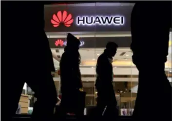  ?? NG HAN GUAN — THE ASSOCIATED PRESS ?? Pedestrian­s walk past a Huawei retail shop in Beijing Thursday. China on Thursday demanded Canada release a Huawei Technologi­es executive who was arrested in a case that adds to technology tensions with Washington and threatens to complicate trade talks.