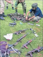  ?? PTI FILE ?? Personnel of the special operation group of J&K Police inspecting the arms and ammunition recovered from four suicide bombers who were killed at Sumbal in Bandipora on Monday.