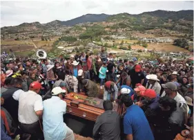  ?? REBECCA BLACKWELL/AP ?? Mourners lower the coffin of community activist Homero Gomez Gonzalez into a grave at a hillside cemetery, in Ocampo, Michoacan state, Mexico on Jan. 31.