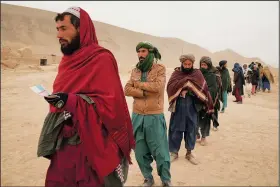  ?? ?? Afghan farmers suffering from consequenc­es of drought line up to receive food rations Dec. 13 at a distributi­on point organized by the Internatio­nal Federation of the Red Cross, in Sang-e-Atash.