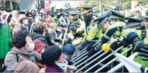  ?? YONHAP/AFP ?? Supporters of South Korea’s ousted president Park Geun-hye clash with police outside her home as she leaves for the hearing yesterday.