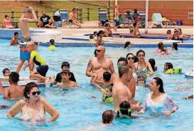  ?? [PHOTO BY PAUL HELLSTERN, THE OKLAHOMAN ARCHIVES] ?? Children and adults enjoy a hot day in the cool water at Pelican Bay Aquatic Center in Edmond.