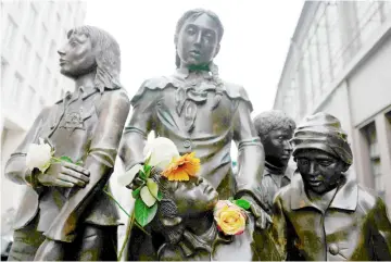  ??  ?? File photo shows flowers are placed at the ‘Trains to Life - Trains to Death’ bronze memorial by sculptor Frank Meisler outside the Friedrichs­trasse station. — AFP photo