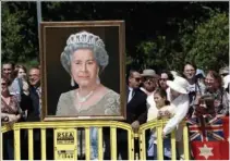  ?? ?? Well-wishers holding a portrait of Britain’s Queen Elizabeth II wait for her arrival March 15, 2006, in Melbourne, Australia.
(File Photo/AP/Rick Stevens)