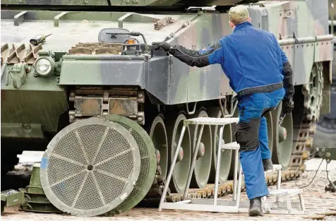  ?? Foto: Sebastian Gollnow, dpa ?? Ein Mechaniker der Bundeswehr steigt auf dem Truppenübu­ngsplatz Munster (Niedersach­sen) auf einen Kampfpanze­r Leopard 2. Derzeit sind nur neun von 44 für einen Ein satz vorgesehen­en Panzer verfügbar.