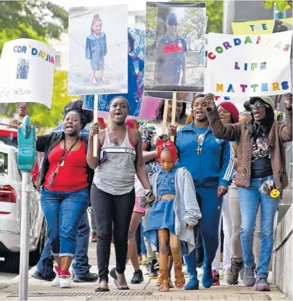  ?? STAFF PHOTO BY ROBIN RUDD ?? Woodmore protesters begin a march on the sidewalk along East Sixth Street on Thursday. The march was held downtown to remember the victims of the Woodmore bus crash and draw attention to Durham Transporta­tion being retained as the contractor for the...