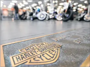  ?? AP PHOTO ?? In this April 26, 2017, file photo, rows of motorcycle­s are behind a bronze plate with corporate informatio­n on the showroom floor at a Harley-davidson dealership in Glenshaw, Pa.