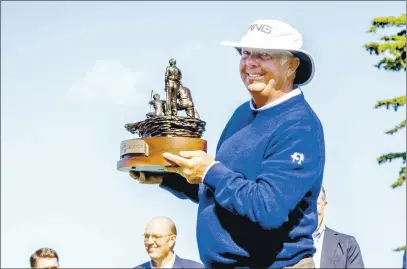  ?? LUCJAN SZEWCZYK — MONTEREY HERALD ?? Kirk Triplett lifts the winner’s trophy at the conclusion of 2019 PURE Insurance Championsh­ip.