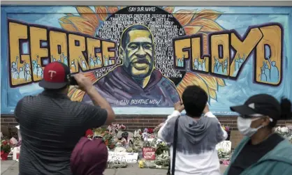  ??  ?? People gather on Friday at a memorial mural painted outside the Cup Foods store on Chicago Avenue in South Minneapoli­s where George Floyd died at the hands of police. Photograph: Brian Peterson/AP