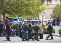  ?? Getty Images/tns ?? Customs and Border Patrol police walk past individual­s that were evacuated from Cielo Vista Mall and a Walmart where a shooting occurred in El Paso, Texas, on Saturday.