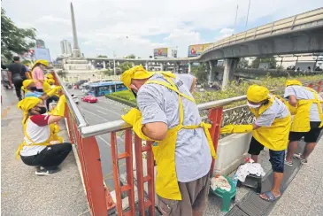  ?? VARUTH HIRUNYATHE­B ?? Homeless and unemployed people who have joined the Mirror Foundation’s campaign to find them jobs clean an overpass near Victory Monument.