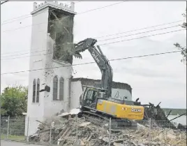  ?? CaROl duNN/TC Media ?? The First United Church building, located on the corner of High and Hampson streets in Trenton, was demolished on Tuesday. The bell tower is shown as it’s knocked down by the excavator.