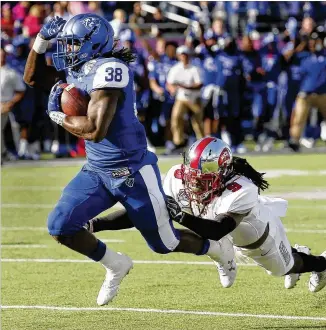  ?? STEPHEN M. DOWELL / ORLANDO SENTINEL ?? GSU’s Demarcus Kirk pulls away for a TD at Saturday’s Cure Bowl in Orlando, Fla. The Panthers set Cure Bowl records in total yards, first downs, rushing yards and third-down conversion­s.