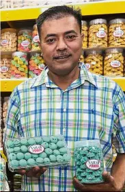  ??  ?? Festive delights: Naharudin displaying his blue chocolate chip Raya cookies named after the national news agency Bernama at his outlet in Johor Baru.