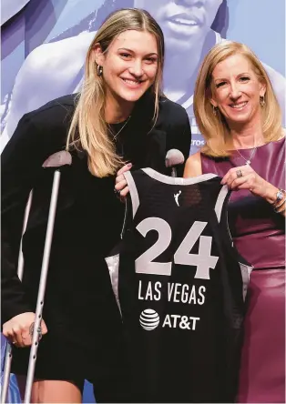  ?? ADAM HUNGER/AP ?? Virginia Tech’s Elizabeth Kitley, left, holds up a jersey with WNBA commission­er Cathy Engelbert after being selected 24th overall by the Las Vegas Aces during the second round of the WNBA draft.