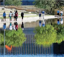  ?? [PHOTO BY JIM BECKEL, THE OKLAHOMAN] ?? Visitors to the Oklahoma City National Memorial walk around the reflecting pool on Thursday.