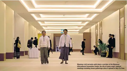  ??  ?? Myanmar civil servants walk down a corridor at the Myanmar Internatio­nal Convention Center, the site of many major regional meetings including Asean gatherings since it opened in Nay Pyi Daw.