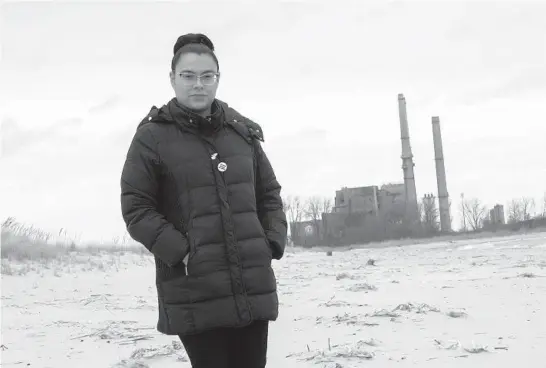  ?? ERIN HOOLEY/CHICAGO TRIBUNE PHOTOS ?? Dulce Ortiz of Clean Power Lake County stands on North Beach with the Waukegan Generating Station coal-fired plant behind her on Wednesday.