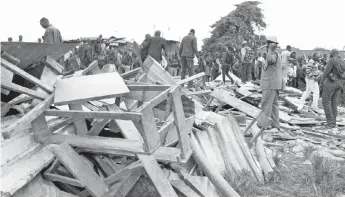  ?? — Reuters photo ?? A police officer stands near the debris of a collapsed school classroom, in Nairobi.