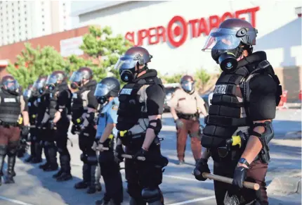  ?? JOHN MINCHILLO/AP ?? Minnesota State Police assemble in front of a Target Store in St. Paul, Minn., late last month.