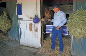  ?? AP ?? Tim Yakteen stands in his barn with Taiba, one of two horses he will saddle for the Kentucky Derby.