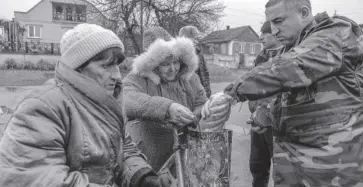  ?? FOTO: AFP ?? Habitantes de la región de Kherson, Ucrania, comparten comida.