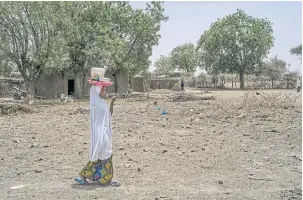  ??  ?? Zeinoura Mahissou, who escaped a forced marriage, carries bean cakes to sell at the market in the village of Inkouregao­u, Niger.