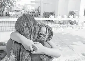  ?? Curtis Compton / Atlanta Journal-Constituti­on ?? Kearston Farr and her daughter Taliyah, 5, embrace while visiting a memorial Friday in front of the Emanuel AME Church in Charleston, S.C. Suspect Dylann Roof is accused of killing nine people Wednesday at the church.