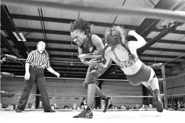  ?? - AFP photo ?? Profession­al wrestler Gia Scott (C) baby checks profession­al wrestler Aria Palmer (R) during Autumn Armageddon 2018 in Galena, Maryland on October 6, 2018.