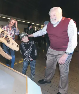  ?? JIM WELLS ?? Wayne Haglund, professor emeritus and the driving force behind the Cretaceous Lands exhibit, shares a laugh with a young visitor at the opening at Mount Royal University on Thursday.