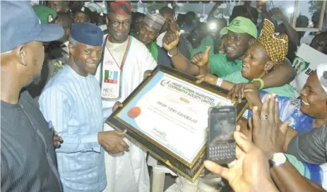  ??  ?? Vice President, Yemi Osinbajo (2nd l), receiving certificat­e of appreciati­on from some Market Moni beneficiar­ies during the Niger State edition of National Micro Small and Medium Enterprise Clinic MSME in Minna, at weekend. With them is Abubakar Sani (3rd l), governor, Niger State.