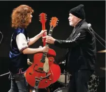  ?? AP PHOTO/EUGENE HOSHIKO ?? Canadian rock legend Randy Bachman, right, receives his stolen Gretsch guitar during the Lost and Found Guitar Exchange Ceremony Friday at the Canadian Embassy in Tokyo.