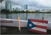  ?? CARLOS GIUSTI/AP 2021 ?? A wooden Puerto Rican flag is displayed on a dock on the Condado Lagoon in San Juan, the capital. The U.S. territory is seeing a spike in housing costs.